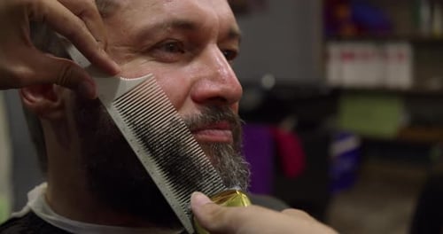 Beard Cut with Blade at Barbershop Professional Hairdresser Shaves His Client's Beard with a Hair
