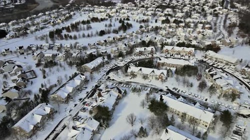 Aerial View a Snowy Winter Day with House Roofs Covered By White Snow