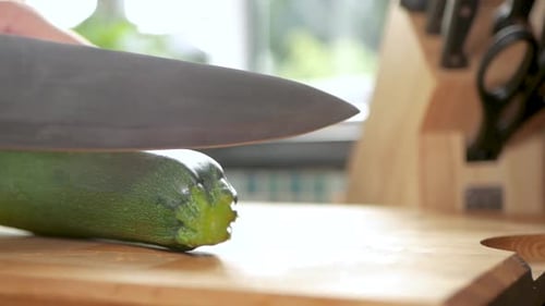 Tir au ralenti coupant le bout d'une courgette.