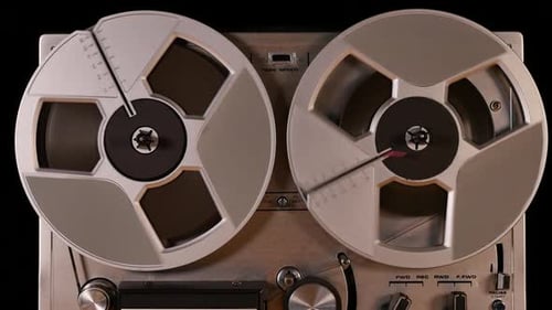 Vintage Reel to Reel tape recorder playing music close up of reel