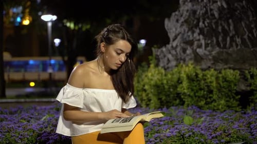 Woman is Reading a Book in The Park