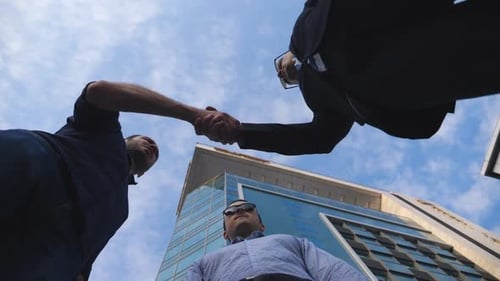 Three Young Businessmen Meeting and Greet Each Other Near Office Building. Male Colleagues Shaking