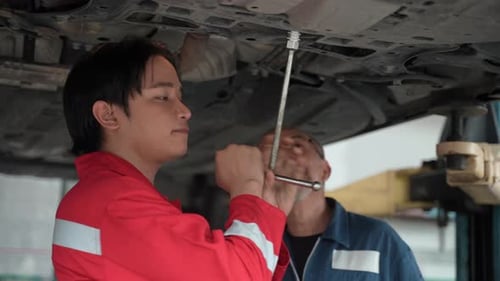 technician man car mechanic working in automotive garage to fix repair suspension auto car