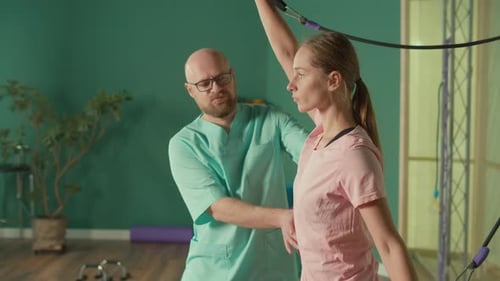 The Personal Trainer Helps the Athlete to Perform Exercises in the Gym